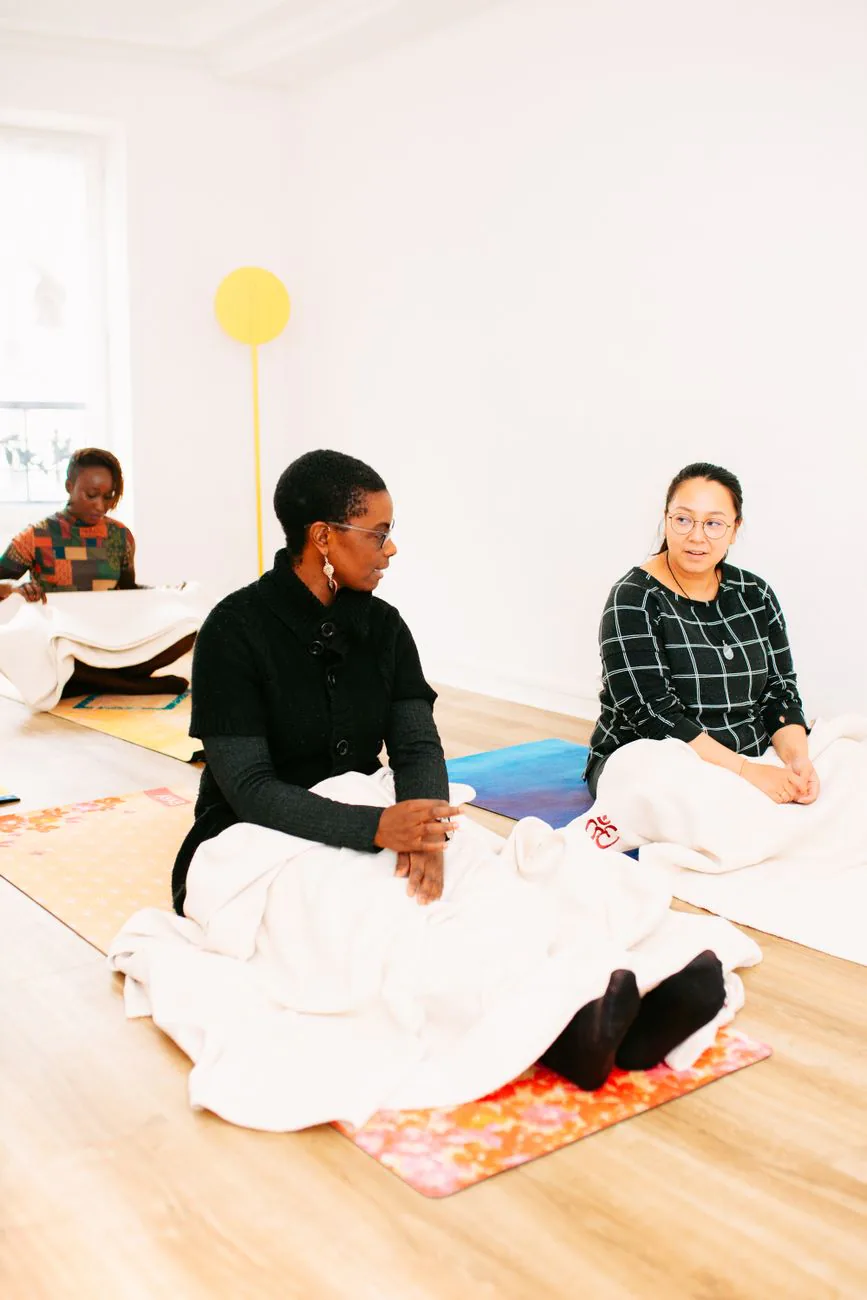 Women meditating together with hands on chest