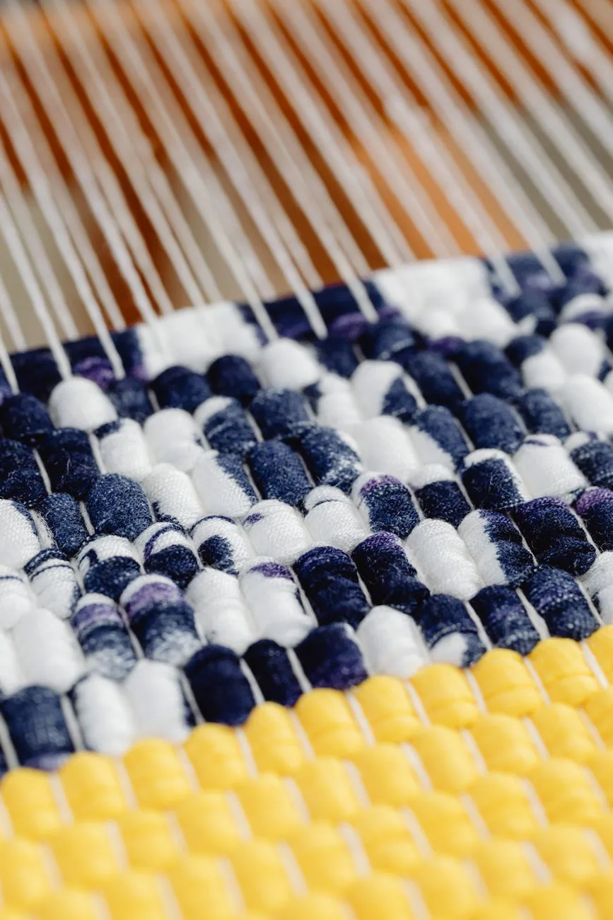 Artisan handweaving fabric on a traditional loom