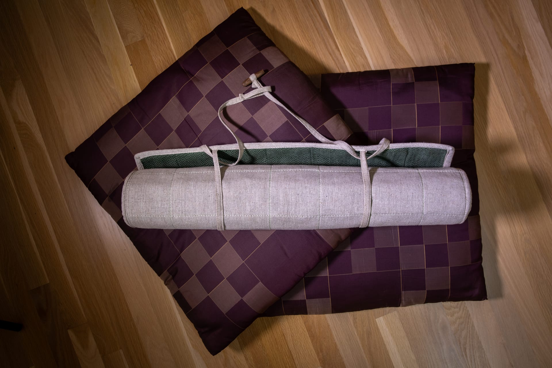 Rolled meditation cushions arranged in a calm practice space