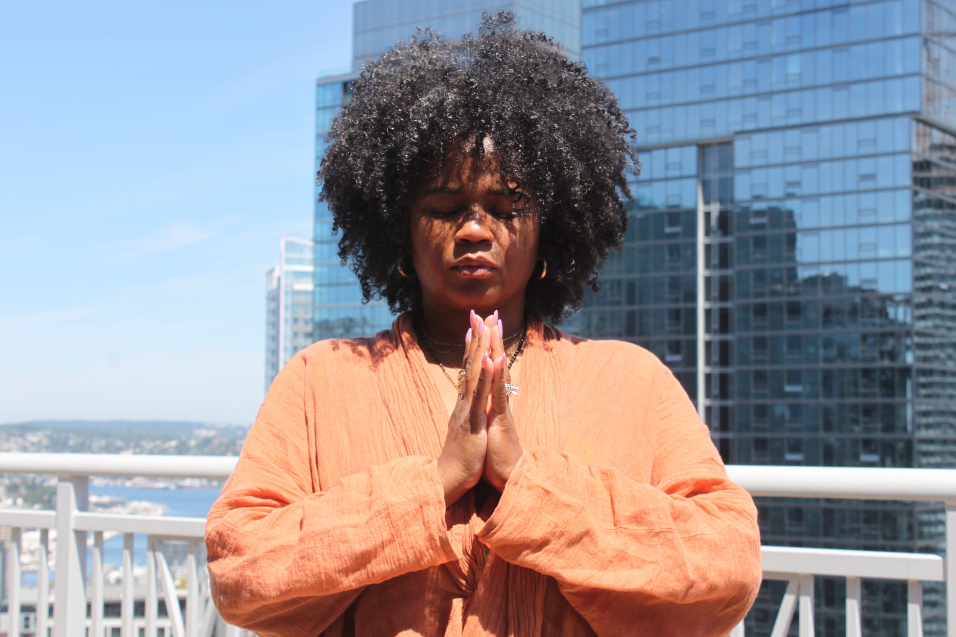 Woman meditating on a city rooftop at dusk