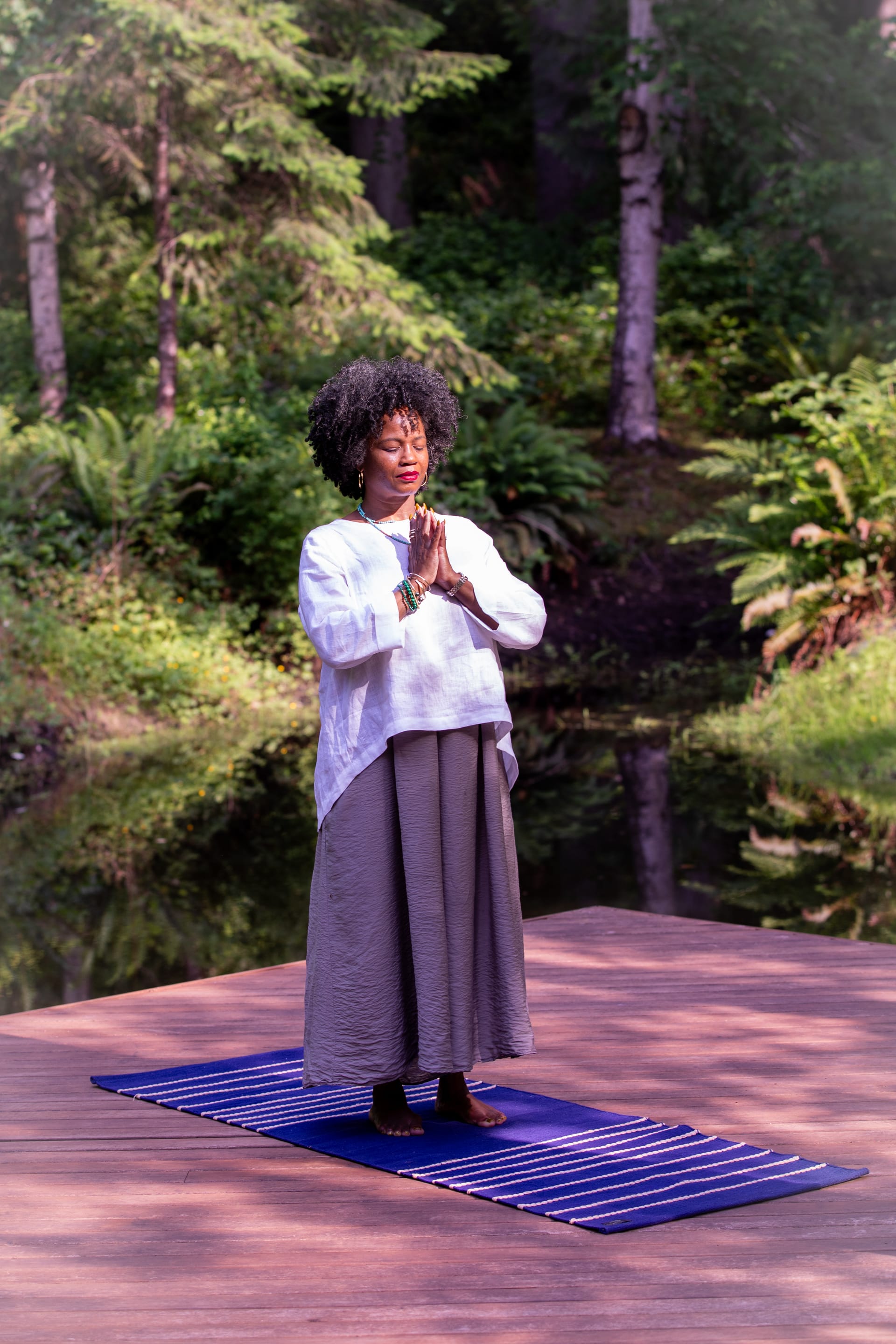 Woman practicing yoga outdoors surrounded by nature