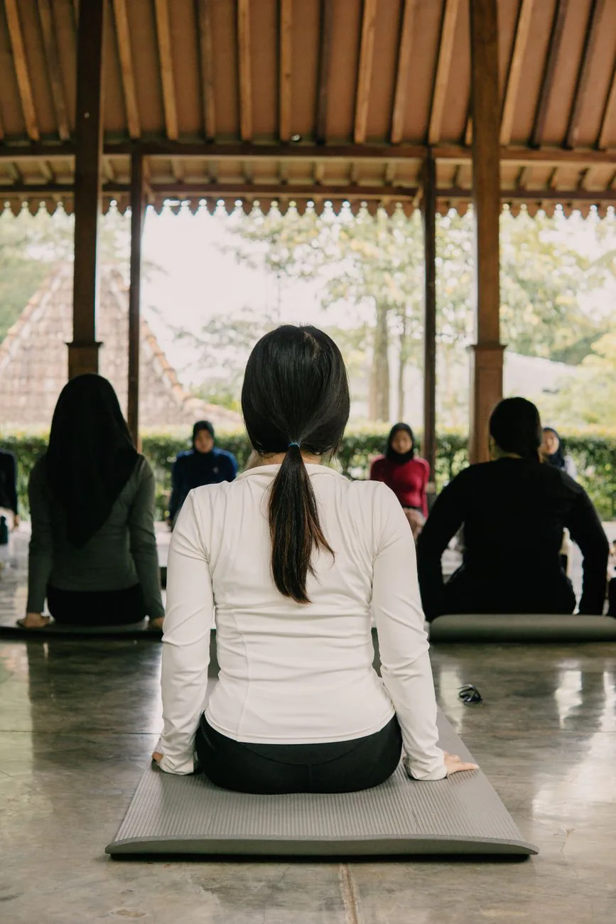 Coworkers meditating together in a modern office