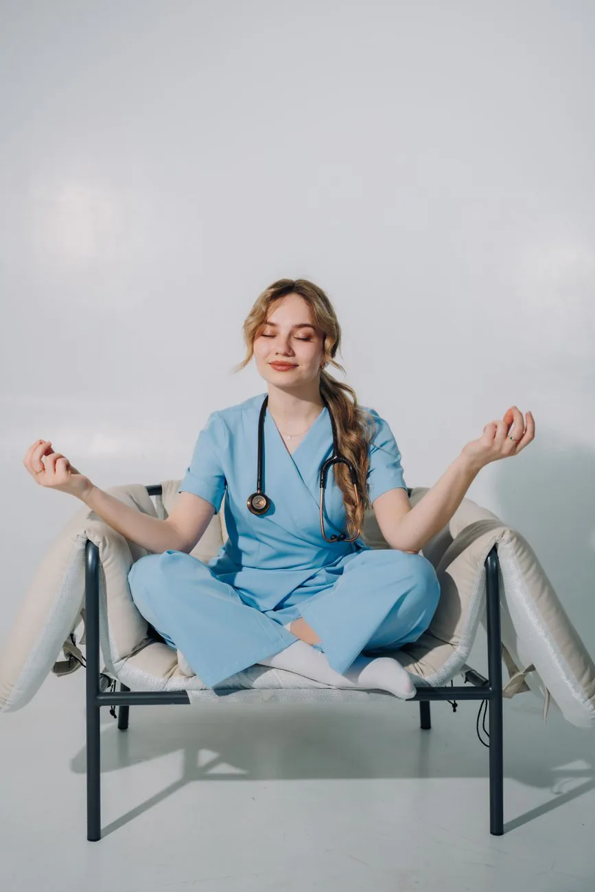 A healthcare professional in scrubs meditating